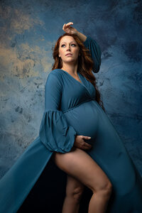 Expecting mother wearing a blue gown during her maternity session.