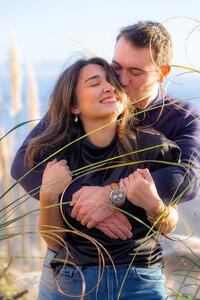 engagement couple in tall grass on beach in santa cruz
