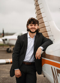 Senior portrait at a small hangar near Mobile International Airport in Mobile, Alabama — posing near airplane