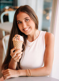 Senior portrait in Gulf Shores, Alabama — close-up holding an ice cream cone with sprinkles.