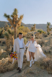 Bride and groom walk side by side in the desert