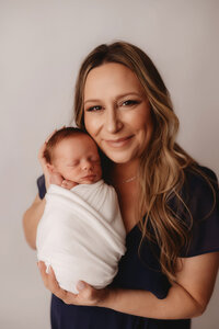 Newborn Photographer in Charleston - Mother embraces her infant during Newborn Portrait Session in Charleston, SC.