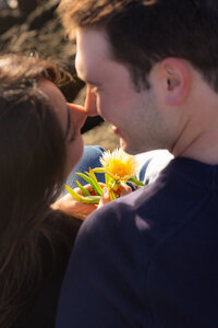 closeup couple on cliffside with flower in santa cruz
