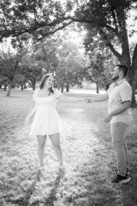 A black and white photo of a couple in a park, captured by an Austin wedding photographer.
