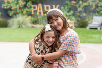 two sisters embracing and laughing in their backyard