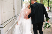 Husband embraces wifes back after ceremony while walking in downtown Knoxville