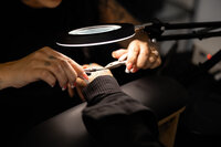 Tattooed brow artist working with precision tools on client’s brows. Photograph by Yucaipa branding photographer Kaitlyn Dawn Photography.