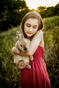 a girl holds a bunny in a field in Flowermound Texas