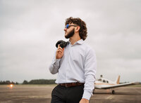 Senior portrait at a small hangar near Mobile International Airport in Mobile, Alabama — suit
jacket over his shoulder, wearing aviators