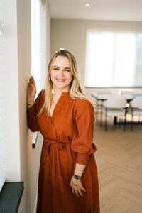 Zakelijk portret van fotograaf die tegen muur leunt in daglichtstudio Studiaux Alkmaar