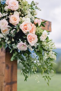Ceremony cross floral arrangement with peach and blush roses, trailing greenery by Flowergirl Cville, Charlottesville wedding florist | Photo by Paige Ryan Photography