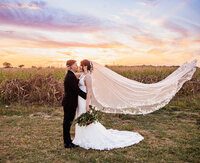 Intimate Bride and groom portrait with veil toss taken during their wedding at Ellis County Event Center by Graceful Ray Photography in DFW.