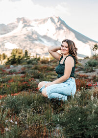 Sam Barlow high school senior sitting with a gorgeous view of Mount Hood behind her up at Timberline Lodge