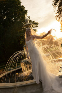 Bride in front of fountain at Keswick Vineyard. Other vendors include Flowergirl Cville and Abby Hart Photography