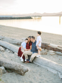 Brackett's Landing South maternity Session in Edmonds. Family is cuddling on a log at sunset.