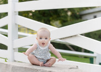 little-girl-outside-in-spring-in-front-of-white-fence