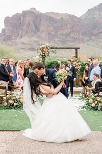 Bride and Groom kissing at end of ceremony aisle  at The Paseo Wedding Venue