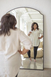 Entrepreneur posing confidently in front of a mirror during a Ventura County brand photography photoshoot.