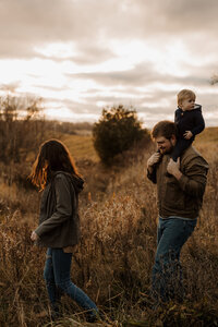 A family walking hand in hand at golden hour in New England. Fine art lifestyle photography capturing intimate and romantic moments outdoors.