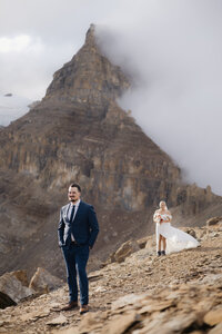 couple shown hiking in yoho national park on their wedding day.