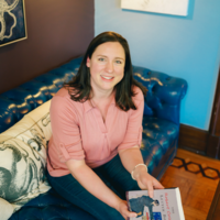 Small business copywriter Kat Jackson sitting on a dramatic blue couch at the best coffee house in the Lehigh Valley.