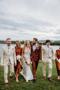 Couple walk and talk with their wedding party on the lawns outside The Marion