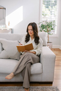 Woman sitting on a couch while posing for her bay area branding photoshoot for her therapy practice