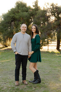 Couple posing together in a park with warm sunset light and natural greenery, Yucaipa outdoor portrait session photographed by Kaitlyn Dawn Photography.