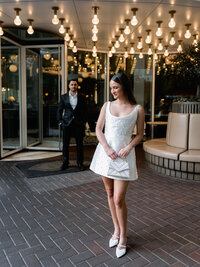 An editorial portrait of a bride in a beaded mini-dress, showcasing a refined composition and the intentional presence of a modern wedding weekend.