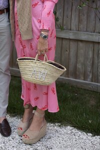 Wedding guests in lobster print dress holds a monogrammed raffia purse. Nantucket Wedding Photographer.