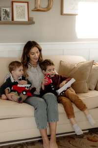 A mother shares a quiet storytime with her sons in their New England home. Fine art lifestyle family photography by Damini Photography.