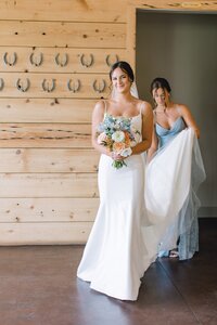 Bride and bridesmaid holding peach and blue bouquets designed by Flowergirl Cville at King Family Vineyard, Charlottesville area wedding | Photo by Paige Ryan Photography