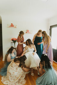 bridesmaids helping the bride into her dress before an Atlanta wedding