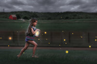 Young girl running at dusk with glowing lights in field in New Bern North Carolina