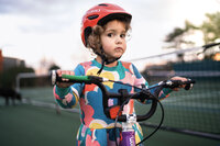 A little girl learns how to ride her bike