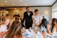 A couple walking into their reception in Redding, CT and greeting their guests.