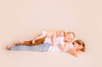 siblings cuddling their newborn brother during a studio session in New Bern