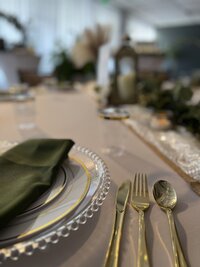 Guest table with classic rustic decor featuring a clear beaded charger plate, emerald napkin, lace runner, and captivating lanterns - Creating a wow factor for your guests