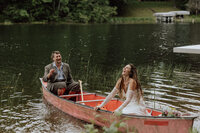 eloping couple laughing in a canoe splashing water at each other. photo taken by a Wisconsin elopement photographer