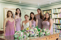 Bride and bridesmaids portrait at a library wedding venue in Los Angeles with elegant lighting, true to life color, and a fine art style.
