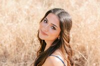 Brunette girl wearing a royal blue dress and looking up at the camera with a soft smile