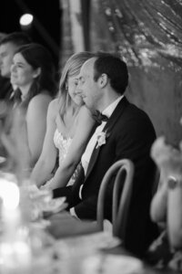 Bride leans into groom during wedding reception