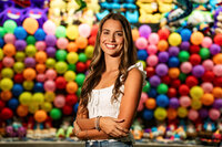 Senior portrait at the Greater Gulf State Fair in Mobile, Alabama — waist-up in front of a wall of
colorful balloons.