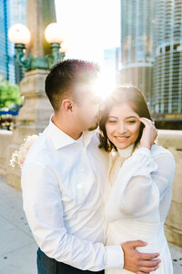The bride and groom walking hand-in-hand along a scenic Chicago riverwalk, the city's reflections shimmering in the water beside them