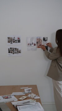 owner Aoife sticking images of a brand onto a wall for inspiration