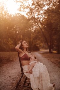 Outdoor photography session of a mother breastfeeding child during sunset