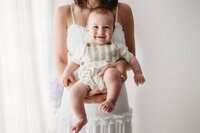 Charleston Mini Sessions - Mother embraces her baby during Mother's Day Mini Session at Holy City Babies in Charleston, SC.