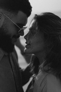 close up of man in aviator shades looking down at a woman