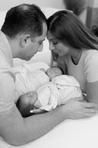 man and woman touching foreheads over sleeping baby for Newborn Photography in Sterling Heights MI