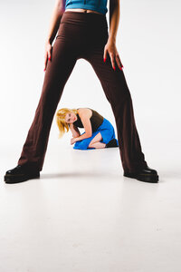 Playful studio portrait of best friends posing together against a bright minimal backdrop.